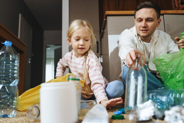Father and daughter sorting recyclables at home