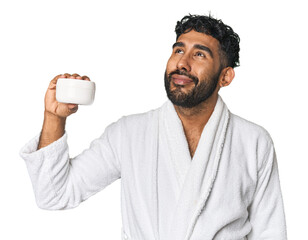 Hispanic male with moisturizer in studio dreaming of achieving goals and purposes