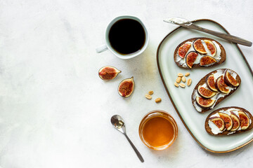 Breakfast with figs and cheese toasts with honey, top view