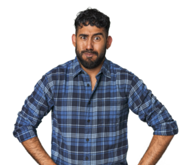 Young Hispanic man isolated blows cheeks, has tired expression. Facial expression concept.