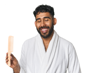 Young Hispanic man with robe holding a comb in studio