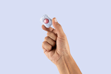 Male hand placing a dishwasher tablet isolated on cyan background cut out