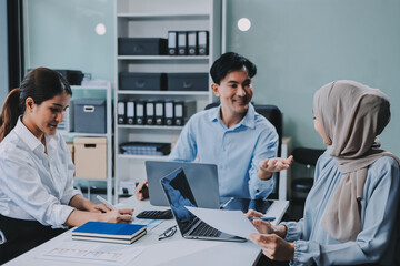 Obraz premium Diverse international executive business partners group discuss report at boardroom meeting table. Multiracial team negotiating project developing business strategy doing paperwork analysis in office.