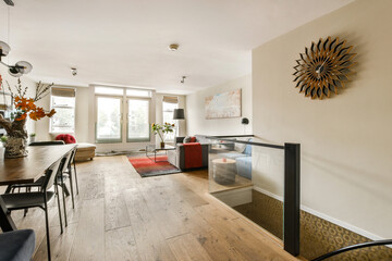 A stylish dining area featuring a modern design with wooden flooring, minimalistic furniture, and...