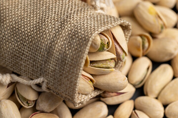 pistachio nuts with cracked shells, poured into a coarse bag, side view
