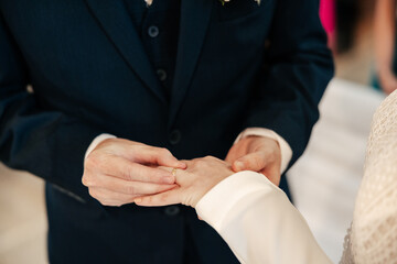 Obraz premium With trembling hands and full hearts, they exchange rings — timeless symbols of their vows, love, and forever. A quiet moment, yet the beginning of the loudest kind of happiness. 