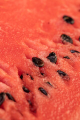 watermelon with pits, part of a sliced juicy watermelon with black seeds