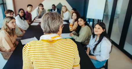 Young students attentively listening to a teacher during a classroom discussion in a modern educational setting