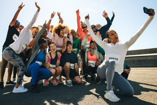 Group of runners taking a cheerful selfie after community run - Powered by Adobe