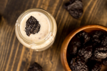 fresh milk yogurt with prune flavor with dried plum slices, jar with natural prune yogurt