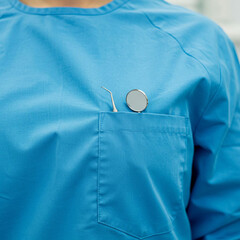 
Female dentist has tools in her pocket, close-up