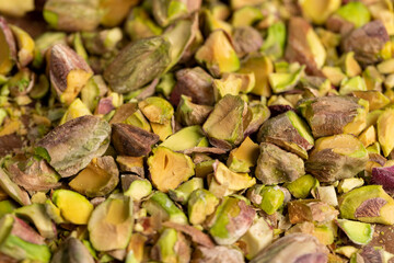 pistachios chopped and crushed into pieces of different sizes, a bunch of green crunchy pistachios, closeup