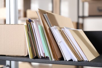 Many different envelopes and parcel on shelf in post office