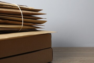 Post office. Different paper envelopes and parcels on wooden table, closeup. Space for text