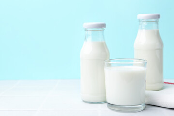 Fresh milk on white table against light blue background. Space for text