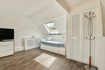 A modern bedroom featuring a cozy bed, minimalist decor, and ample natural light filtering through the windows. The wooden floor adds warmth to the space.