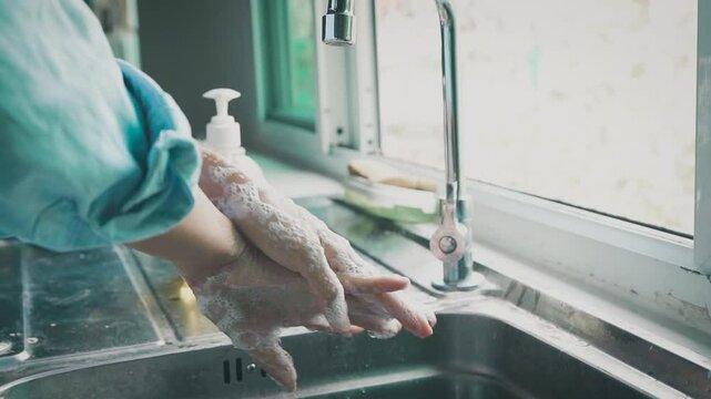  woman washes her hands with soap and water, ensuring cleanliness and health by removing dirt and germs for better hygiene.