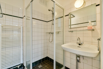 A sleek, modern bathroom showcasing a glass shower enclosure with a contemporary sink. The design features clean lines and minimalist decor.