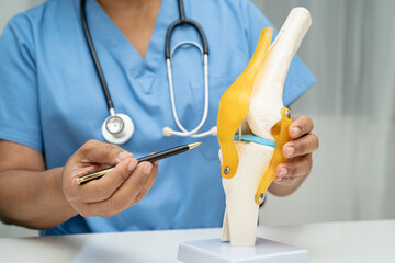 Asian doctor holding spinal nerve and bone model, Lumbar spine displaced herniated disc fragment...