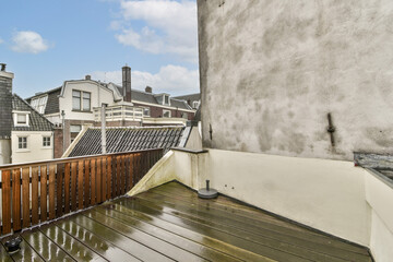 Obraz premium A sleek urban terrace showcasing a rain-soaked wooden deck against a backdrop of contemporary buildings. Ideal for outdoor relaxation or gatherings.