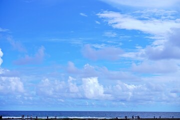 Scenic view of the ocean with a blue sky and clouds.