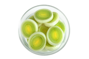 sliced Leek vegetable in glass bowl isolated on white background. Top view. Flat lay