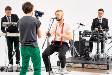 Band Rehearsal with Lead Singer Being Filmed by Cameraman..