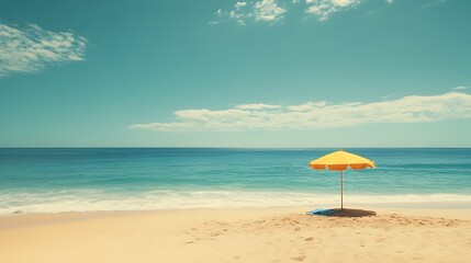 Lonely yellow beach umbrella on sandy shore under a blue sky.