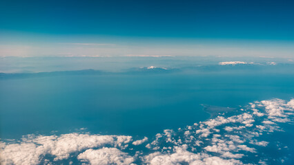view from the airplane window landscape above the clouds