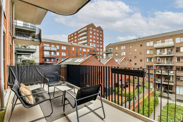 A stylish balcony overlooking contemporary apartment buildings and a vibrant courtyard, showcasing urban living and design aesthetics.