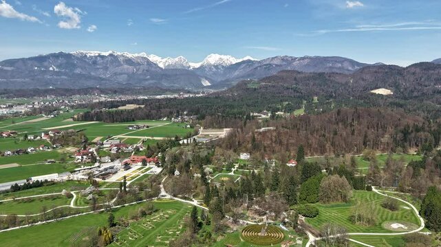 Aerial Timelapse with Kamnik region in Slovenia in spring season against snow covered Alpine range 