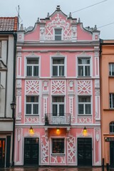 Fototapeta premium Nestled in a charming old town, this stunning historic building features intricate architectural details and a vibrant pink facade that truly comes alive at dusk