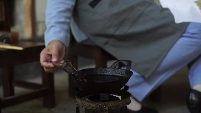 Batik Artist Dipping Canting into Hot Wax for Pattern Making