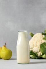 Fresh pear smoothie with cauliflower on gray background for healthy lifestyle