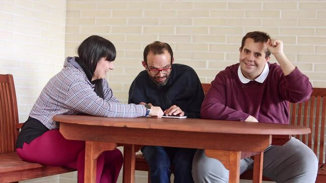 Care worker assisting residents with a tablet in a mental health facility