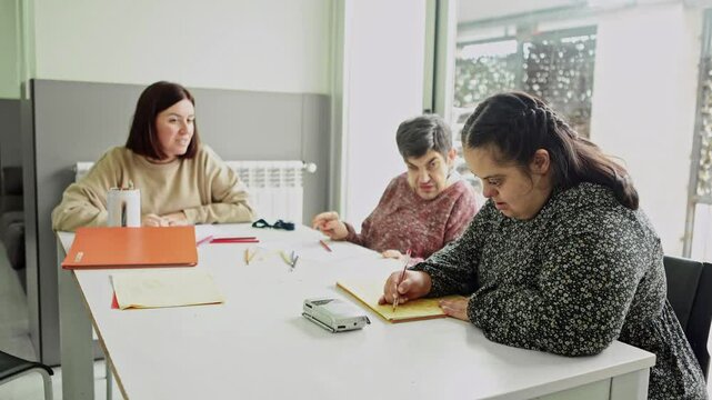 Care worker assisting residents with mental disabilities in activities