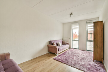 A stylish minimalist interior featuring a comfortable sofa and large windows that allow natural...