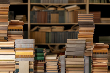 Stacks of many books on a shelf or table. Concept of library, reading, old classic literature