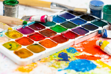 Watercolor paint in old used plastic palettes, brushes, creative mess
