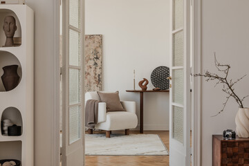 Minimalist living room with sculptural vases, dried branch decor and a neutral color palette...