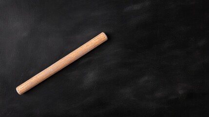 Rolling pin rests on dark surface, showcasing simplicity and fun