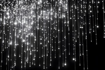 Abstract image of many bright shiny light strands hanging down against black background.
