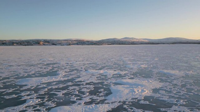 aerial view of frozen sea water into bay fjord norway at sunset