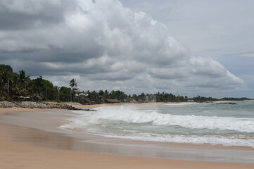 Indian Ocean rocku coast with rocks and high waves and blue sky and white clouds on a sunny day in Tangalle, Sri Lanka