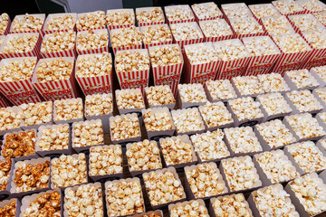 A large assortment of popcorn is spread out on a table. Top view of popcorn boxes.