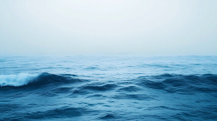 Calm ocean waves under a misty sky.