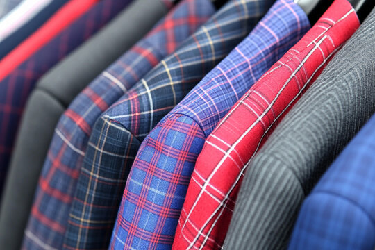 Chaos of getting dressed for work or school with various plaid jackets and blazers hanging together