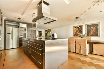 Stylish and contemporary kitchen featuring sleek cabinets, an island, and tasteful art. The design blends function and aesthetics harmoniously.