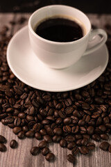 Roasted coffee beans. View from above. A cup of strong coffee on coffee beans