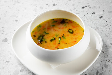 A steaming bowl of vibrant soup, featuring a blend of vegetables and herbs infused with rich flavors. This healthy dish is perfect for warming the soul and enjoying a comforting meal.